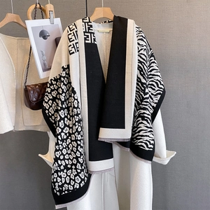 Detail of knit scarf featuring leopard and zebra patterns with geometric jacquard stitching