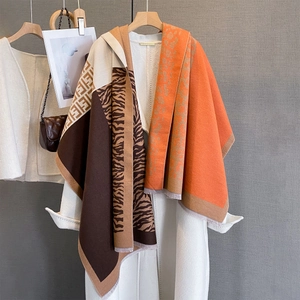 Detail of leopard and tiger print knit scarf with fringe edge and geometric patterns
