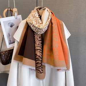 Warm leopard and zebra print jacquard scarf with fringe trim draped over a coat