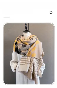 Detail of cashmere-like scarf showing yellow ginkgo leaf pattern and fine fringe edge