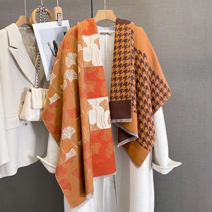 Detail of cashmere-like scarf featuring orange ginkgo leaf and houndstooth patterns