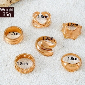Macro view of six gold wave rings set with size labels and engraved chain textures