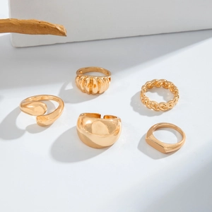 Detailed view of 5-piece gold wave stackable ring set with smooth and braided textures