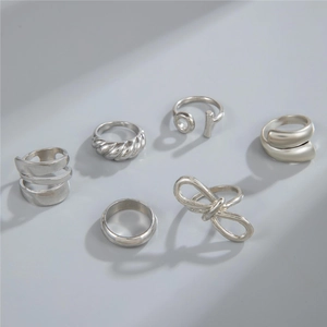 Set of six minimalist silver rings featuring twisted texture and geometric crossover designs