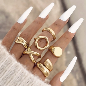 Detail shot of a six-piece gold wave and crossover ring set worn for a trendy layered look