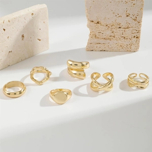 Detail of six-piece gold stackable ring set including wave and cross-wrap designs