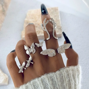 Silbernes Ring-Set mit Schmetterlings-, Flügel- und Geweih-Design auf Steinhintergrund