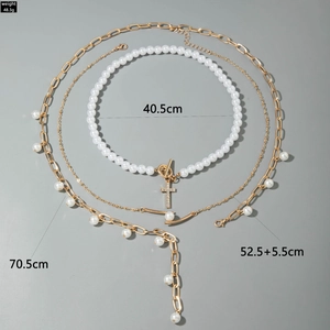 Detailansicht des mehrlagigen Goldketten-Sets mit Kreuz, Perlen und OT-Knebelverschluss