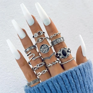 Close-up of bohemian silver ring set featuring butterfly, snake, and floral motifs