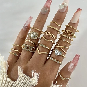 Close-up of bohemian gold ring set featuring heart shapes, wavy lines and crystal accents