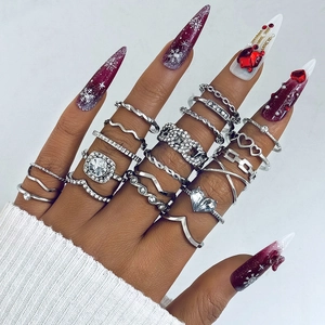 Macro shot of silver ring set with butterfly, moon and heart motifs on a model's hand