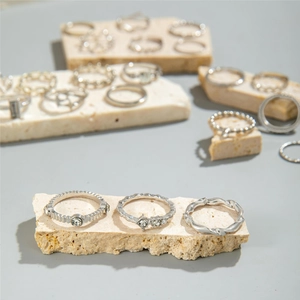 Detailed view of silver stacking rings with zircon inlay and braided texture on stone