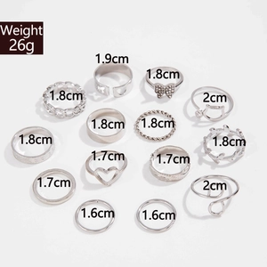 Flat lay of 14-piece silver ring set with butterfly, heart and leaf designs on white