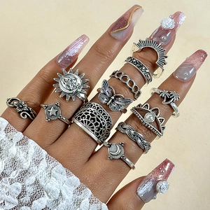 Detailed view of vintage silver rings with sun, moon, and butterfly designs on hands