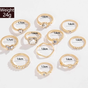 Detailansicht von 11 goldenen Ringen mit Herz, Schmetterling und Kristallen im Set