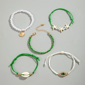 Detail view of 5-piece beach jewelry set with seashells, starfish and pearls on grey background