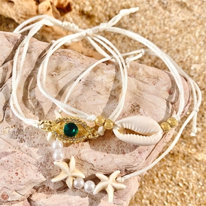 Detailed view of bohemian beach anklets with starfish, shell and evil eye charms