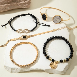Detail of 5-piece bohemian bracelet set with shell, evil eye and infinity charms