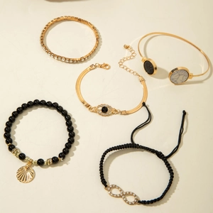 Detail view of five-piece set featuring starfish, evil eye, and shell charm bracelets