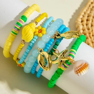 Detailed view of bohemian layered bracelets with sea shells and colorful clay beads