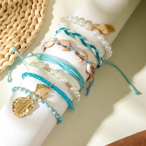 Detail of bohemian beach jewelry set with sea shells, pearls, and turquoise beads
