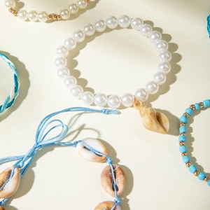 Detailed shot of Bohemian shell and starfish bracelets with pearls and ocean beads