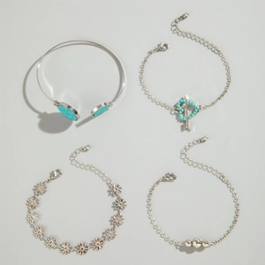 Detail of bohemian four-piece silver jewelry set featuring turquoise stones and leaf motifs