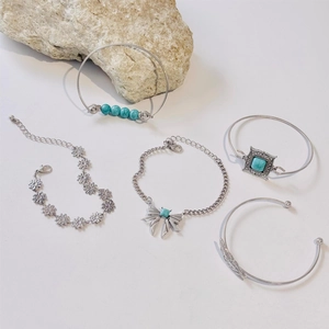 Detailed view of silver Bohemian bracelets featuring turquoise beads and leaf charms