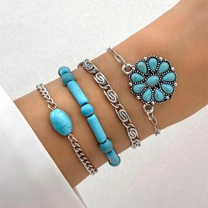 Close-up of Bohemian turquoise bracelet set featuring floral charms and silver link chains