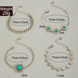 Detail of silver bohemian bracelets with turquoise stones, flower charms and link chains