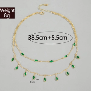 Detail of double-layer gold chain necklace with green charms and 8g weight specs
