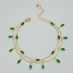 Detail view of double-layer gold chain with green marquise gemstone leaf pendants