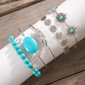Detailed set of 4 bohemian bracelets with turquoise stones and feather charm on display