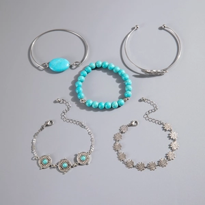 Flat lay of five-piece Bohemian jewelry set with turquoise beads and feather leaf charms