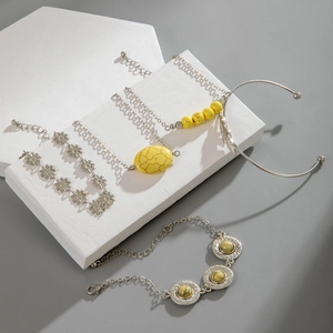Detail of four-piece Bohemian bracelet set with turquoise leaf and sun flower motifs
