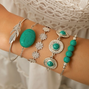 Detail of bohemian 5-piece silver bracelet set with turquoise stones and leaf feather charms
