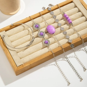 Detail of bohemian silver bracelets with purple turquoise stones and floral charms
