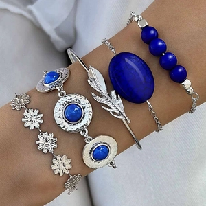 Detail of four-piece silver bohemian bracelet set with turquoise stones and leaf charm