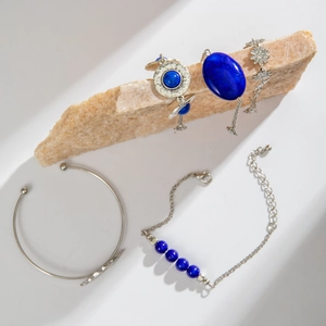 Close-up of bohemian silver bangles and blue turquoise beaded bracelets on a stone