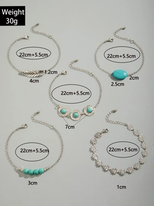 Detailed view of bohemian turquoise anklet set with feather charms and sun patterns