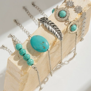 Bohemian silver bracelet set featuring turquoise beads and intricate feather charms