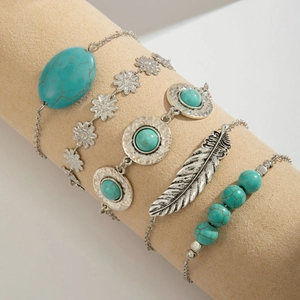 Detailed macro view of bohemian silver bangles with turquoise stones and feather charm