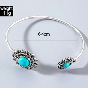 Detail view of Bohemian silver bangle with turquoise stone inlay and sunflower motif