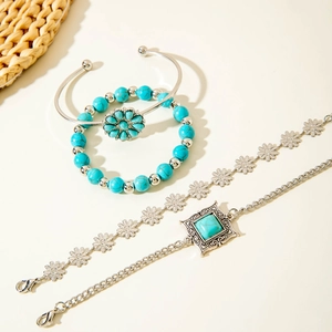 Detail of four-piece Bohemian silver bracelet set with turquoise beads and floral charms