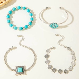 Detail showing set of four bohemian silver bracelets with turquoise beads and floral motifs