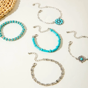 Close-up of bohemian silver bangles with turquoise beads and sun flower charms