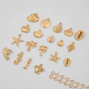 Macro view of gold starfish shell and turtle charms set for ocean theme jewelry