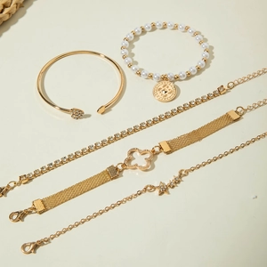 Détail d'un lot de 5 bracelets dorés avec perles, strass et breloques en trèfle