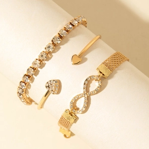 Ensemble de trois bracelets dorés avec symbole infini, jonc cœur et bracelet tennis
