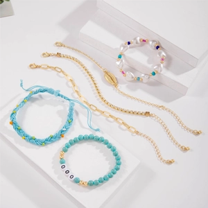 Five-piece bohemian beach bracelet set with blue beads and a gold shell charm